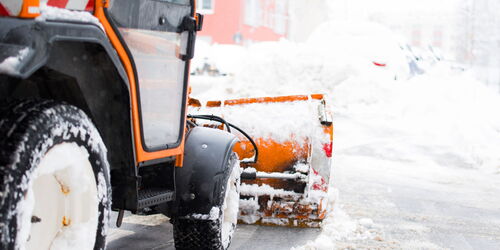 Eine Schneemaschine schiebt den Schnee